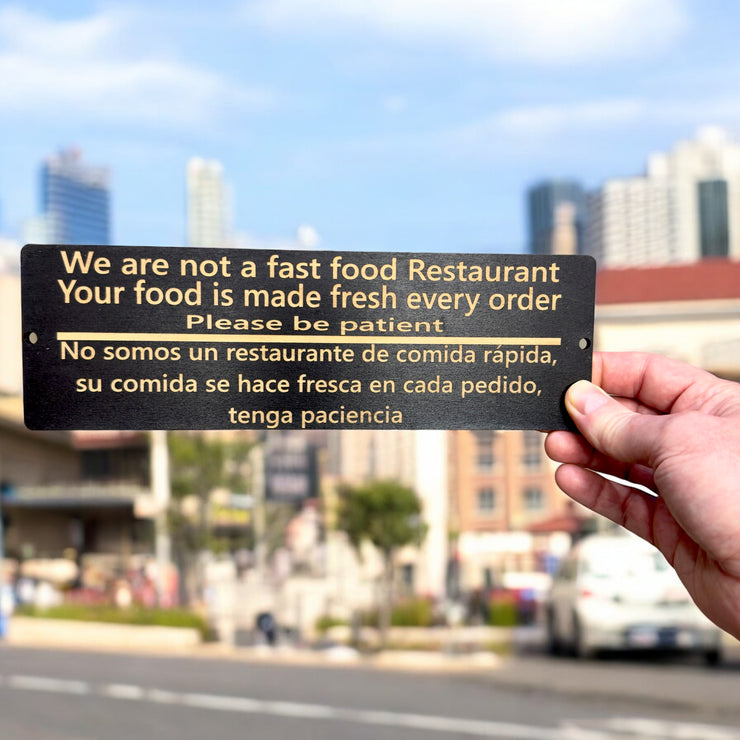 Sign - English & Spanish - We are not a fast food restaurant Please Be Patient