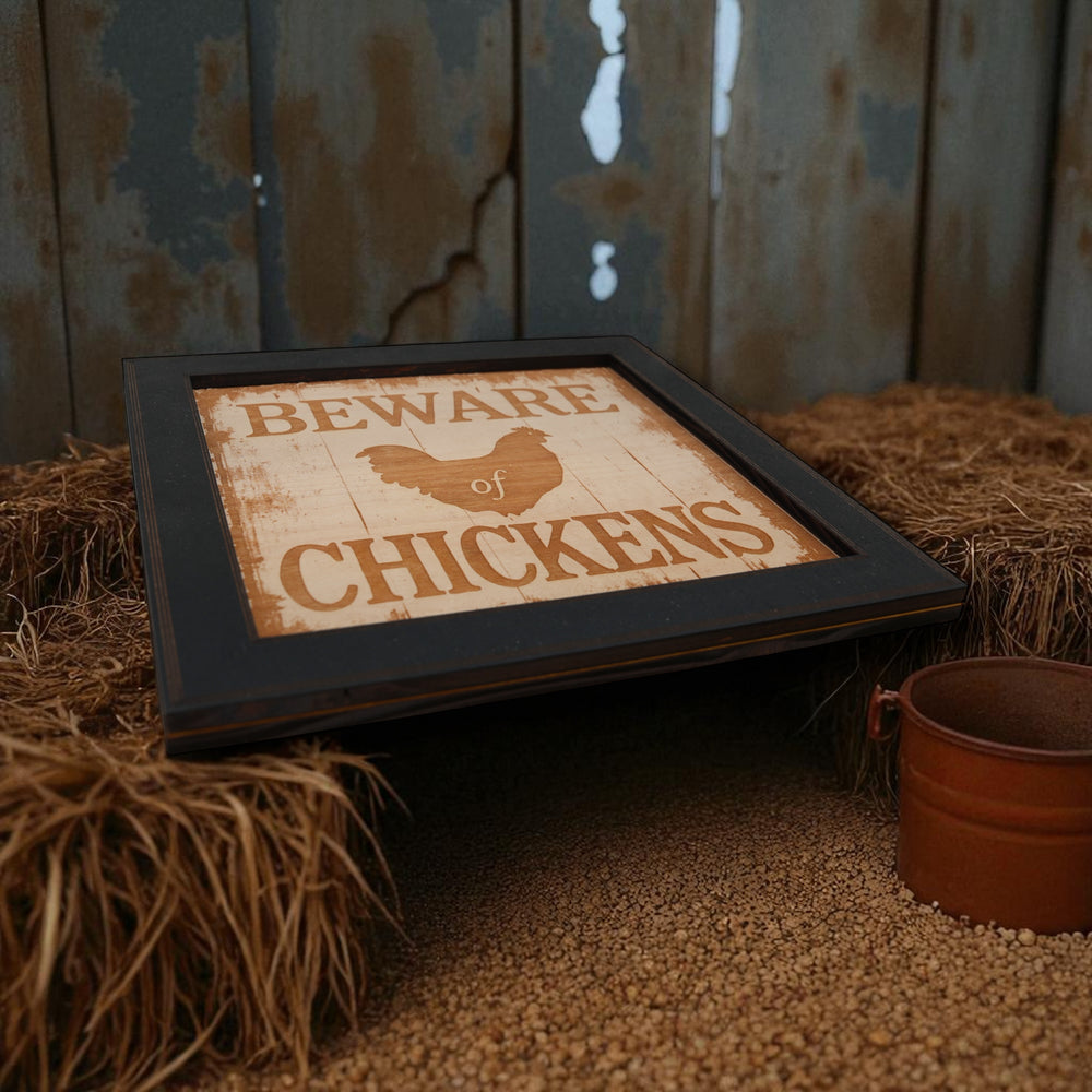 HipFlaskPlus Beware of Chickens engraved wood wall art in a black frame on hay