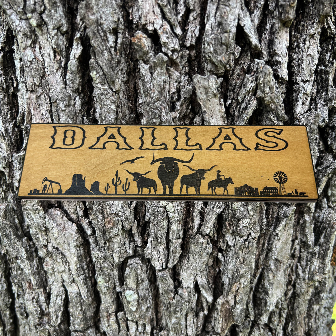 HipFlaskPlus Dallas landscape black and natural wood sign on a tree trunk