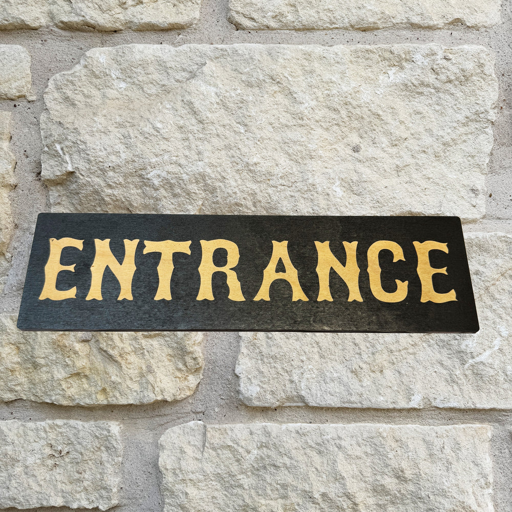 HipFlaskPlus Entrance black and natural wood sign on a stone wall