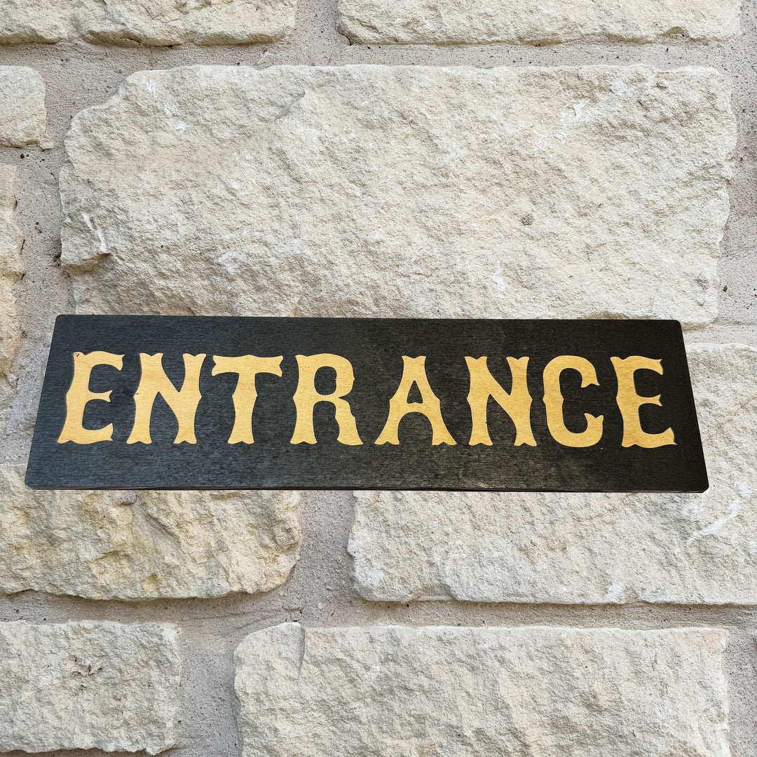 HipFlaskPlus Entrance black and natural wood sign on a stone wall