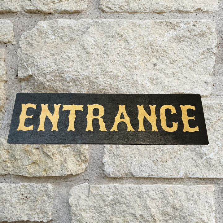 HipFlaskPlus Entrance black and natural wood sign on a stone wall