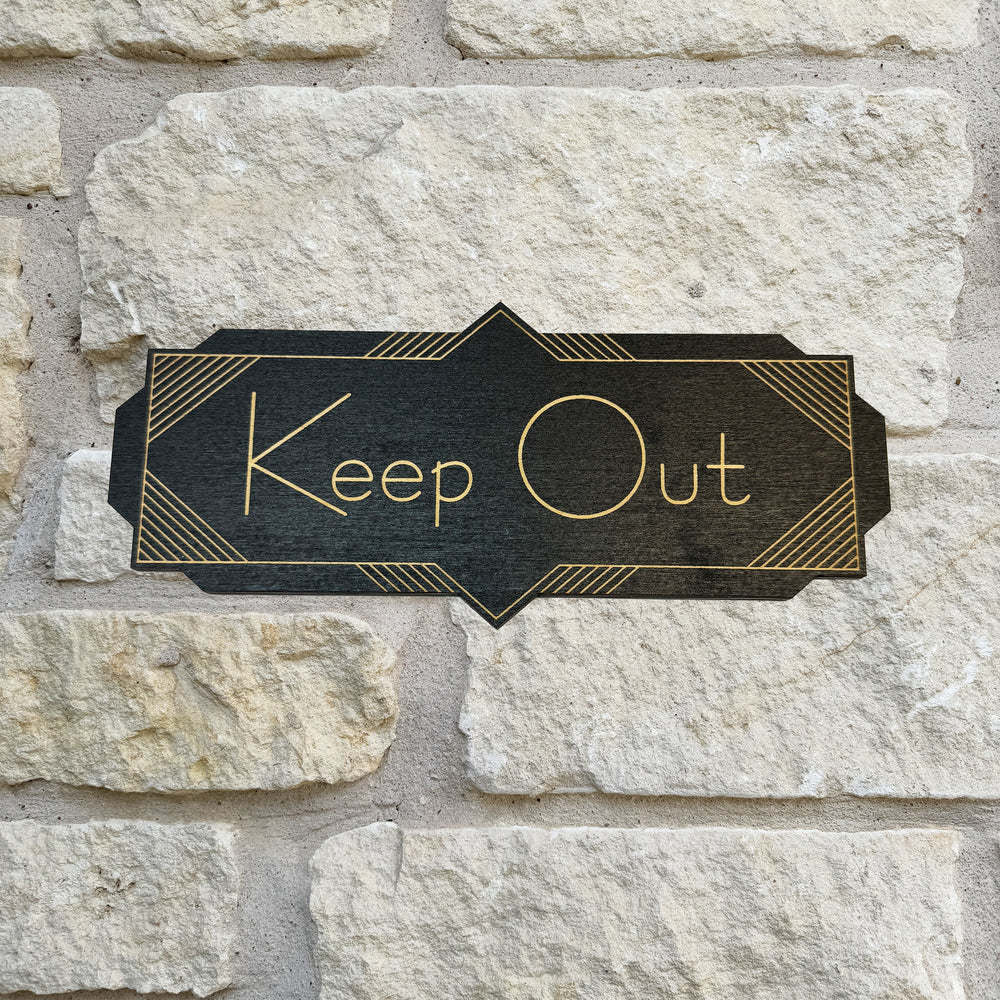 HipFlaskPlus Keep Out black art deco wood sign on a stone wall