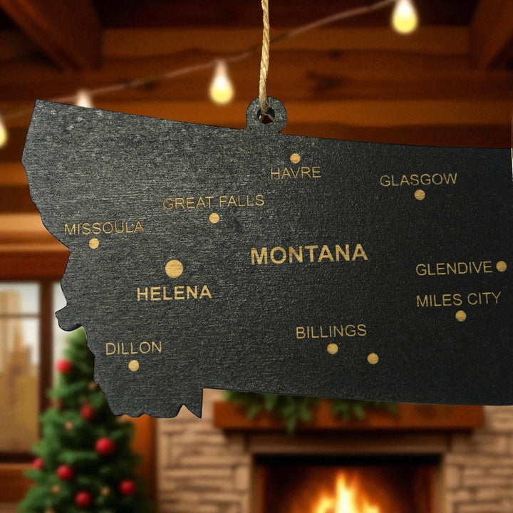 HipFlaskPlus custom Montana state ornament with cities hanging in a cozy cabin by a fireplace