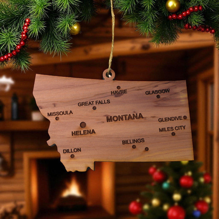 HipFlaskPlus custom Montana state ornament with cities hanging in a cozy cabin by a fireplace