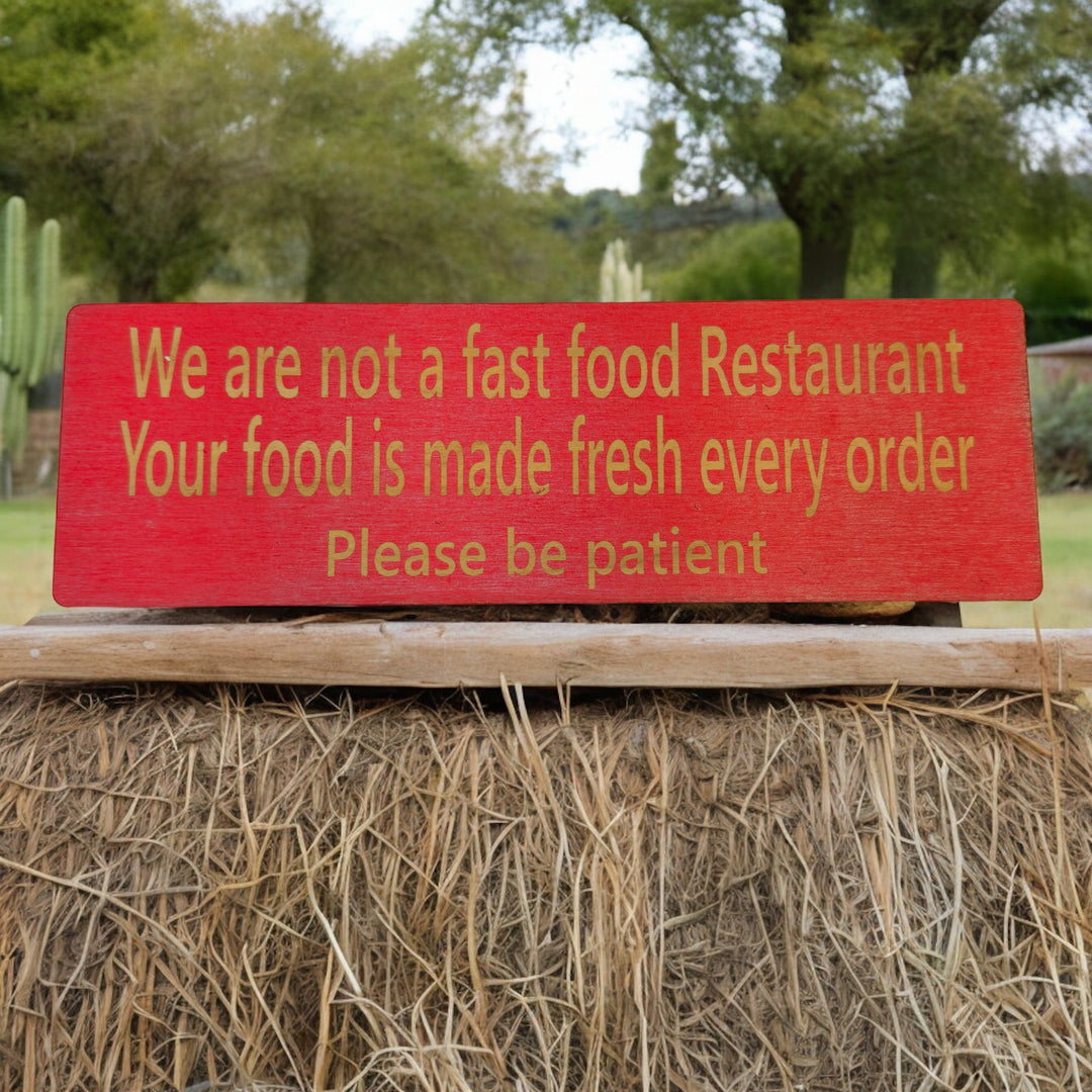 HipFlaskPlus custom We Are Not a Fast Food Restaurant Please Be Patient sign in red on hay