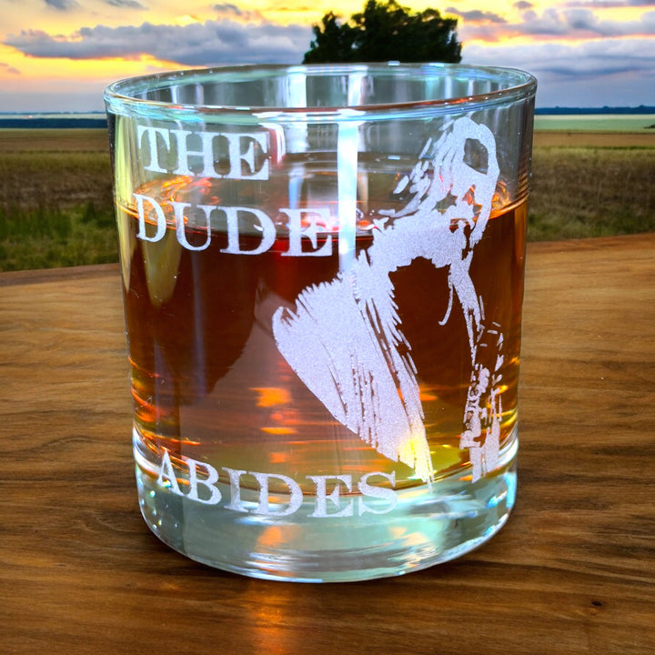 HipFlaskPlus rocks glass engraved with The Dude Abides on a wood table outdoors