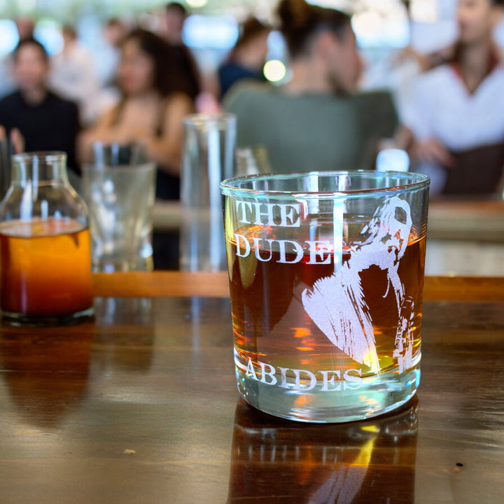 HipFlaskPlus rocks glass engraved with The Dude Abides on a table at a party