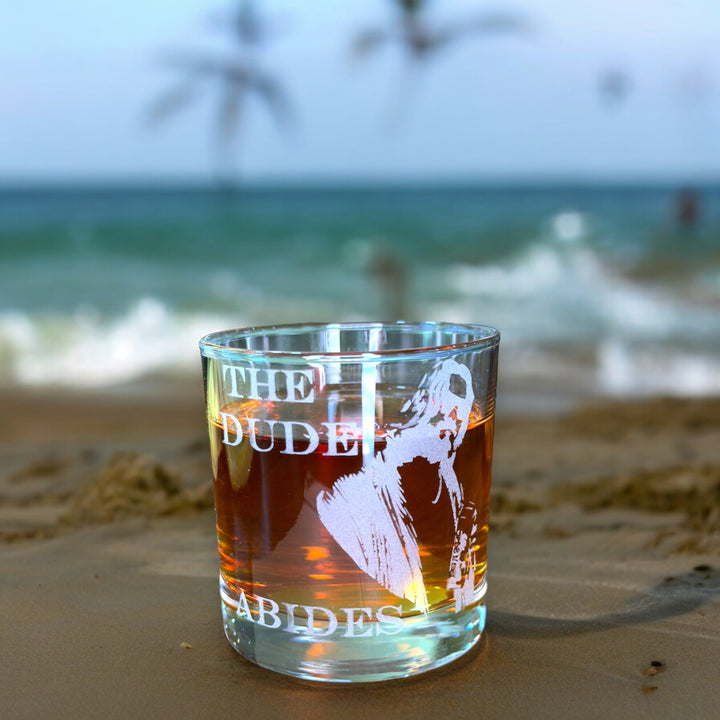 HipFlaskPlus rocks glass engraved with The Dude Abides on a sandy beach