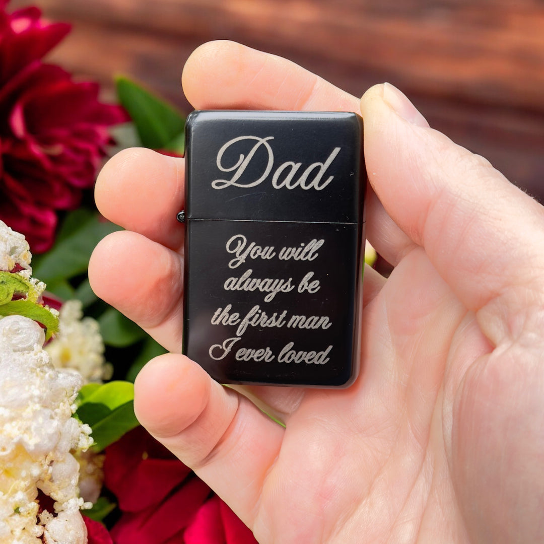 Hand holding a HipFlaskPlus black Dad first man I ever loved lighter beside red and white roses
