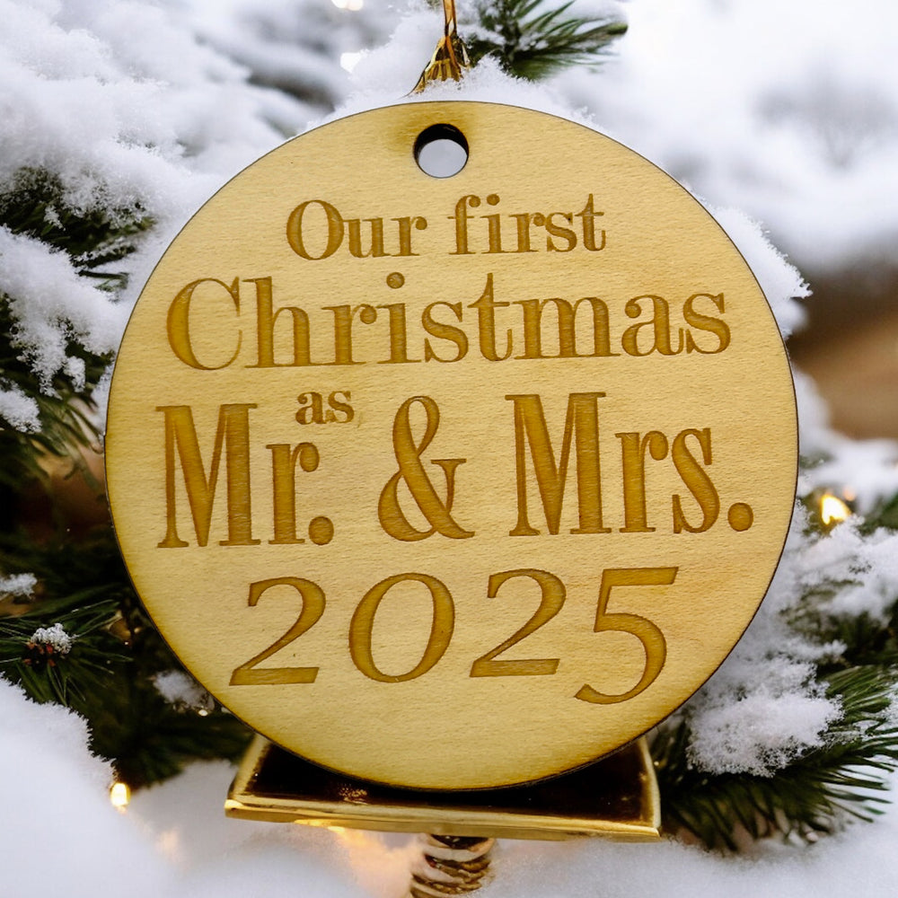 HipFlaskPlus raw wood Our First Christmas as Mr. & Mrs. 2025 ornament on a snowy pine