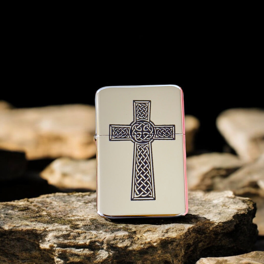 HipFlaskPlus Celtic cross chrome lighter on rocks against a black background