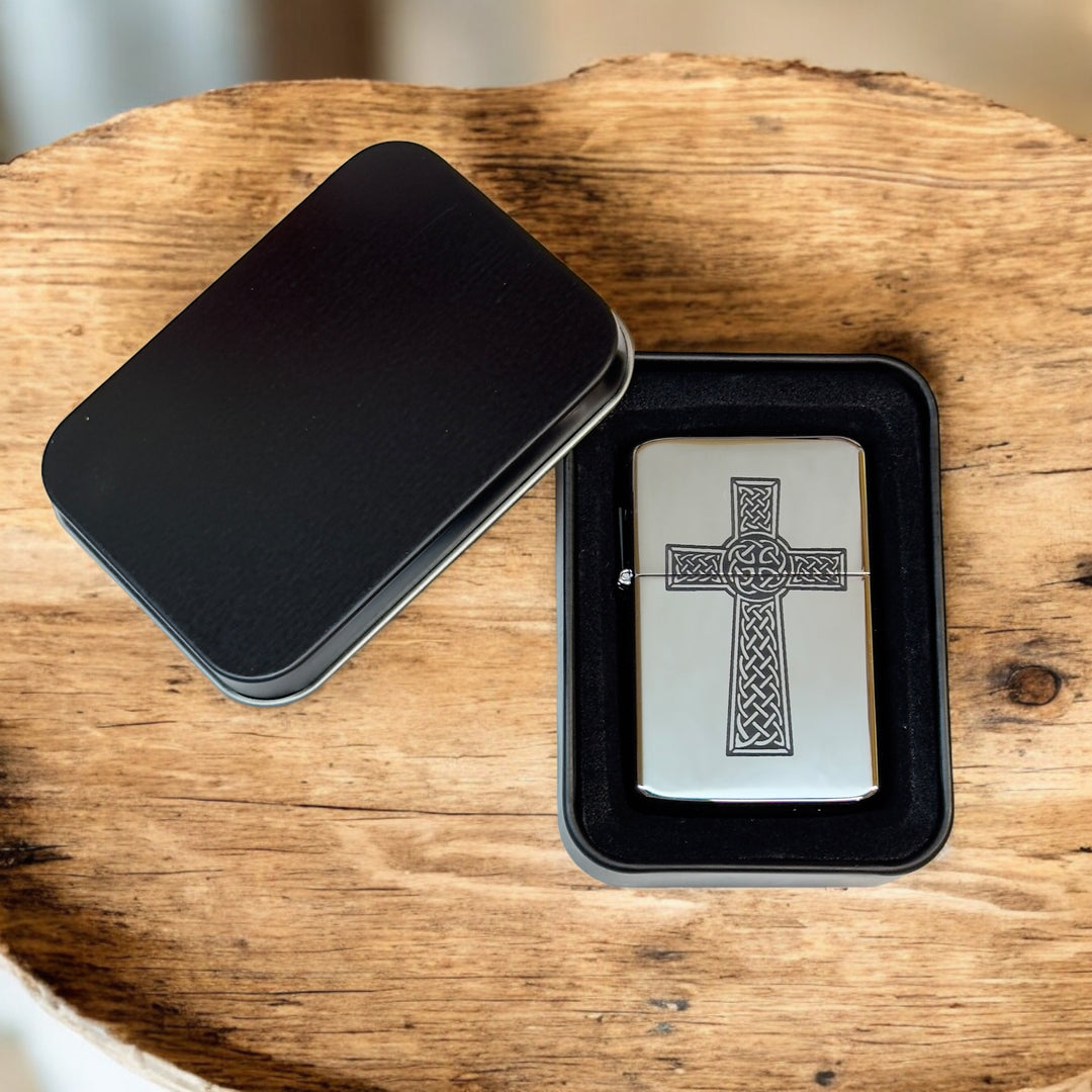HipFlaskPlus Celtic cross chrome lighter in an open black gift tin on a wood slab