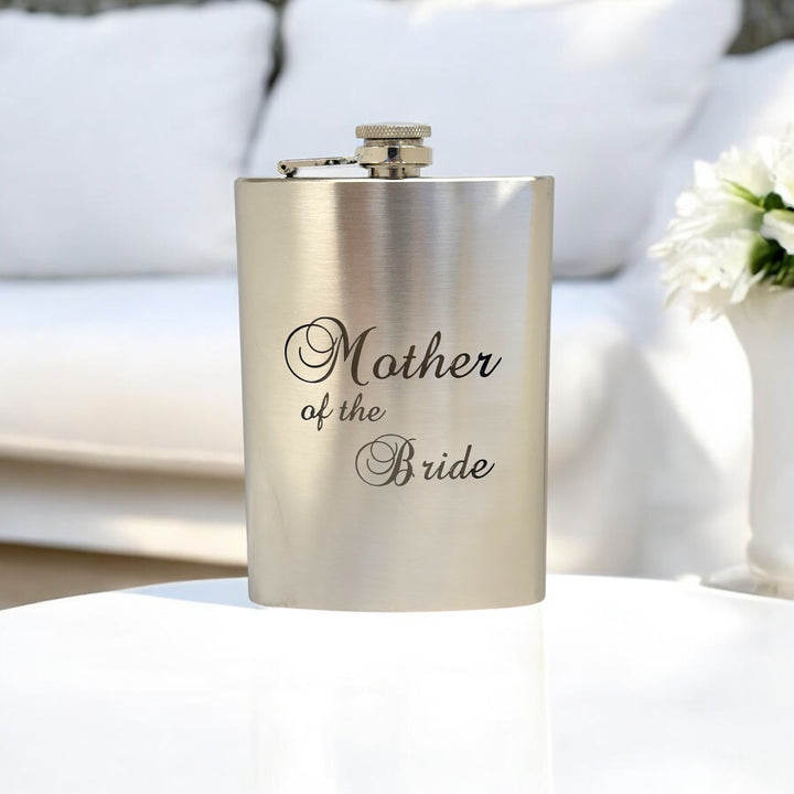 HipFlaskPlus 8oz stainless steel hip flask engraved with Mother of the Bride on a white table