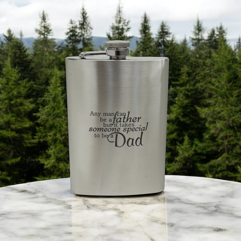 HipFlaskPlus 8oz stainless steel hip flask engraved with Any Man Can Be a Father by a forest