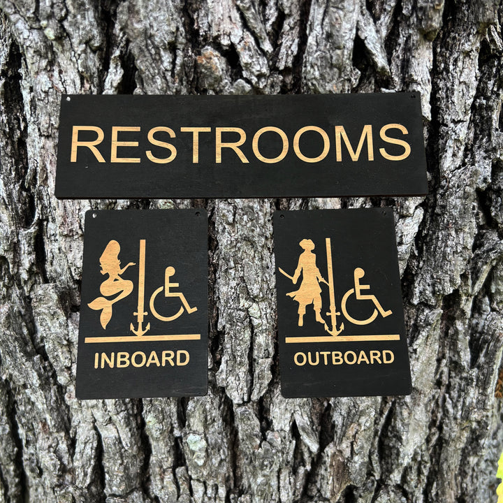 HipFlaskPlus Restrooms Inboard and Outboard black wood signs on a tree trunk