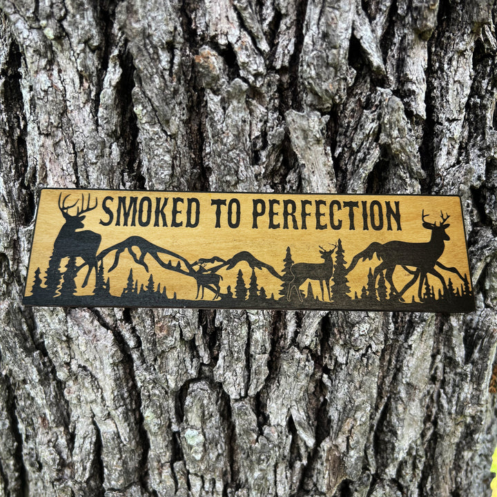 HipFlaskPlus Smoked to Perfection deer scene black and natural wood sign on a tree trunk