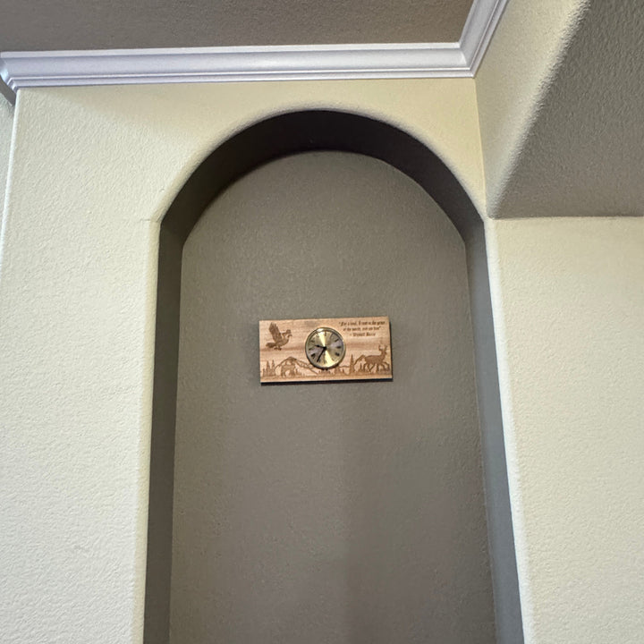 HipFlaskPlus rustic cedar picket wall clock with laser-engraved deer and bird scene mounted in an arched wall niche.