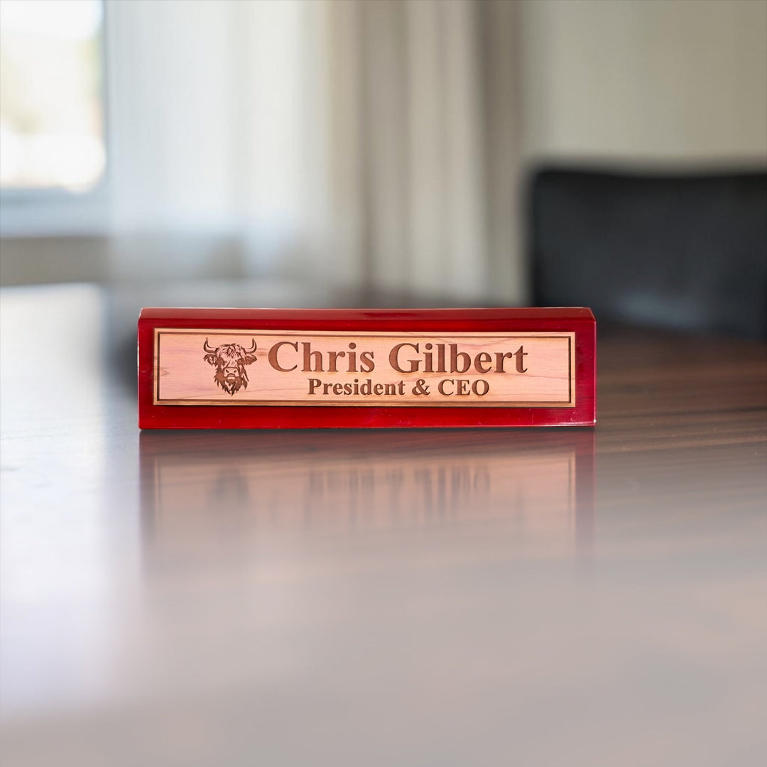 HipFlaskPlus personalized 11-inch desk wedge name plate with Highland Cow engraving and rosewood piano finish.