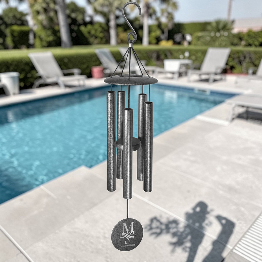 HipFlaskPlus personalized black powder-coated aluminum wind chime with laser-engraved horse design hanging by a pool.