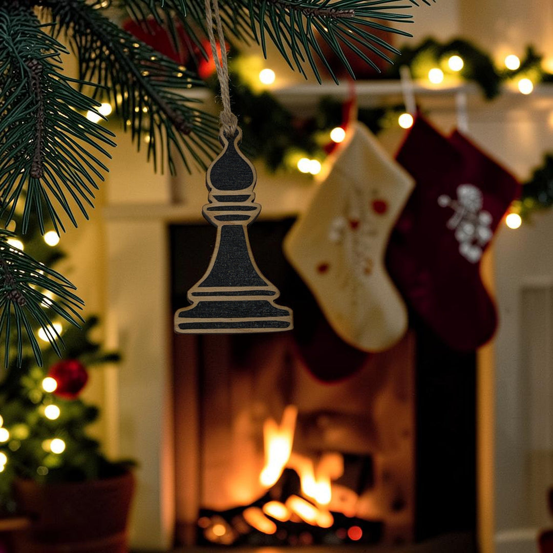 HipFlaskPlus laser-cut wooden chess bishop ornament hanging on a Christmas tree with a fireplace in the background.