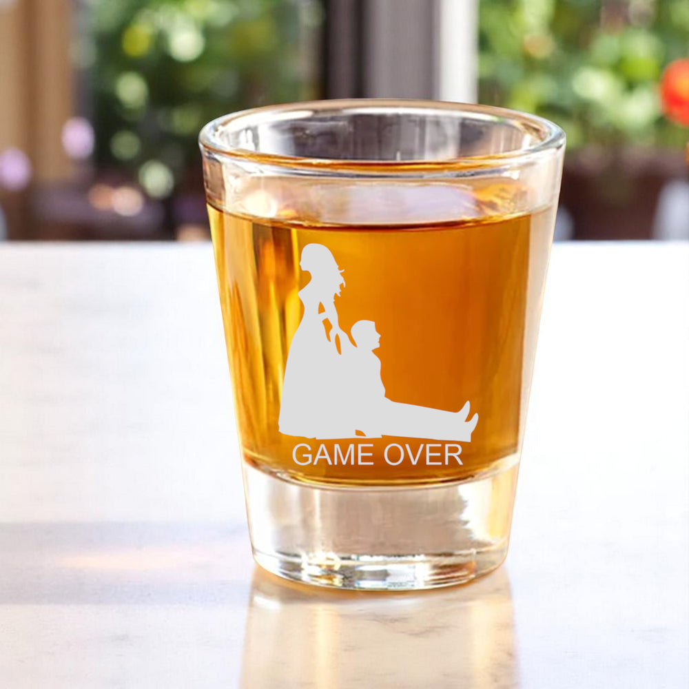 HipFlaskPlus Game Over bride and groom engraved shot glass with whiskey on a white table